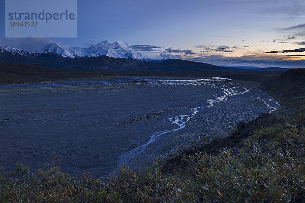 Der Thorofare River schlängelt sich hinunter zum McKinley River  während der Denali in der Herbstdämmerung im Denali National Park & Preserve  Alaska  aufragt.