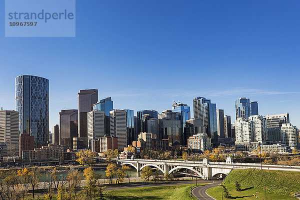 Skyline von Calgary mit Brücke über den Fluss  herbstlich gefärbten Bäumen und blauem Himmel; Calgary  Alberta  Kanada'.