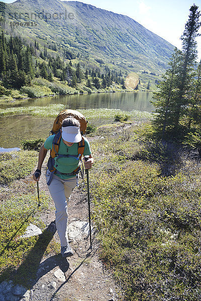 Rucksacktouristin wandert entlang des Upper Fuller Lake im Kenai National Wildlife Refuge auf der Kenai-Halbinsel in Süd-Zentral-Alaska