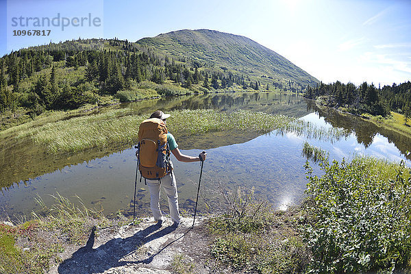 Rucksacktouristin wandert entlang des Upper Fuller Lake im Kenai National Wildlife Refuge auf der Kenai-Halbinsel in Süd-Zentral-Alaska