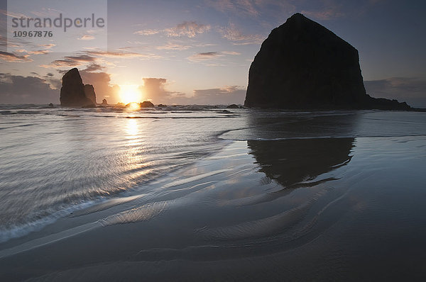 Sonnenuntergang hinter Haystack Rock; Cannon Beach  Oregon  Vereinigte Staaten von Amerika'.