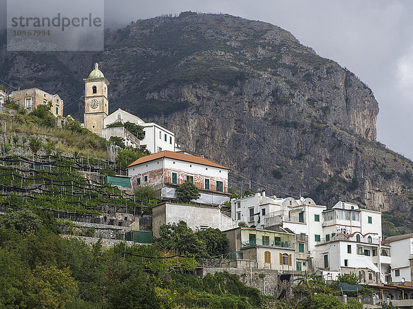 Häuser auf einem Hügel und ein großer Berg entlang der Amalfiküste; Amalfi  Italien'.