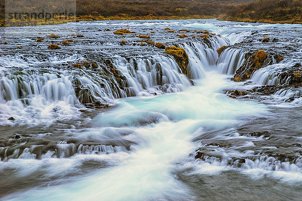Wasser  das über Felsen stürzt und in einen Fluss fließt; Bruarfoss  Island'.