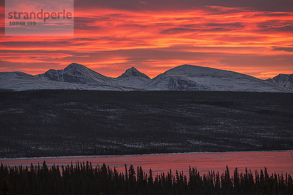 Sonnenuntergang über der Rancheria-Gebirgskette und dem eisbedeckten Swan Lake; Yukon  Kanada'.