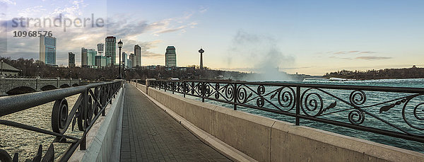 Ein Spazierweg mit der Skyline der Stadt im Hintergrund; Niagarafälle  Ontario  Kanada