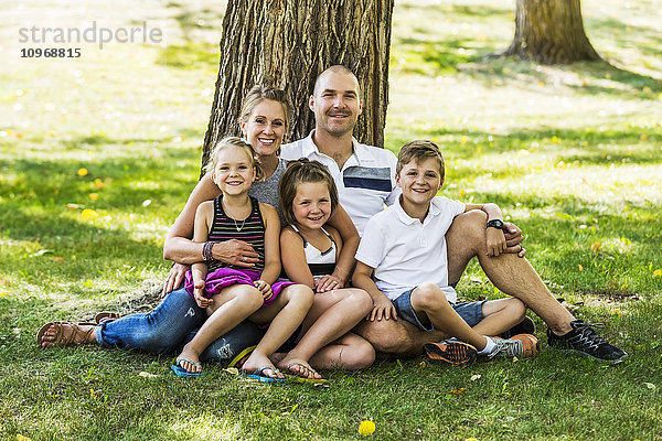 Eine Familie posiert für ein Familienporträt in einem Park; Edmonton  Alberta  Kanada'.