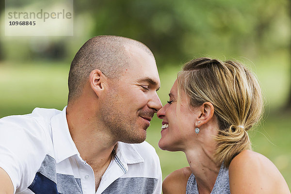 Ein Mann und eine Frau küssen sich in einem Park; Edmonton  Alberta  Kanada'.