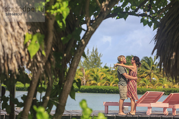 Paar auf einem Holzsteg in einer Umarmung  Saint Georges Caye Resort; Belize City  Belize'.