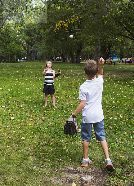 Bruder und Schwester spielen Fangen in einem Park während eines Familienausflugs; Edmonton  Alberta  Kanada'.