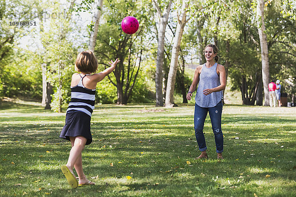 Mutter und Tochter werfen einen Ball in einem Park während eines Familienausflugs; Edmonton  Alberta  Kanada'.