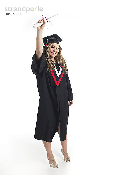 Junge Absolventin hält ihr Diplom in die Höhe  um ihren Abschluss zu feiern; Edmonton  Alberta  Kanada'.