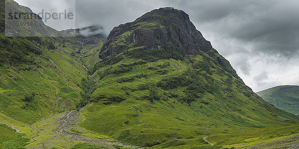 Gewitterwolken über zerklüfteten und laubbedeckten Bergen; Schottland'.