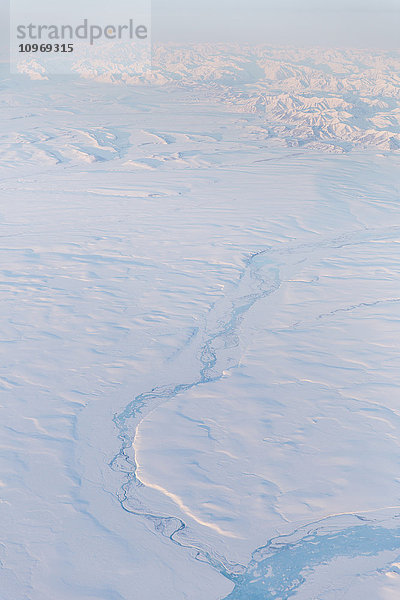 Luftaufnahme eines teilweise zugefrorenen Flusses  der durch eine schneebedeckte Tundra-Landschaft fließt  North Slope  Arctic Alaska  USA  Winter