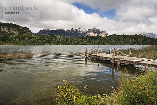 Ein hölzerner Steg führt den Blick auf einen kleinen Bergsee; Bariloche  Argentinien'.