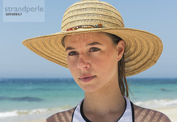 Porträt einer jungen Frau am Strand mit Sonnenhut; Tarifa  Cadiz  Andalusien  Spanien'.