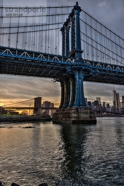 Manhattan- und Brooklyn-Brücke bei Sonnenuntergang  Brooklyn Bridge Park; Brooklyn  New York  Vereinigte Staaten von Amerika'.