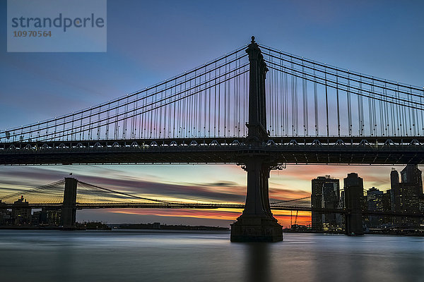 Sonnenuntergang hinter der Manhattan- und der Brooklyn-Brücke; New York City  New York  Vereinigte Staaten von Amerika'.