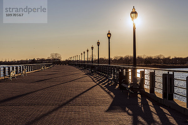 Sonnenuntergang hinter Laternenpfählen  Liberty State Park; Jersey City  New Jersey  Vereinigte Staaten von Amerika'.