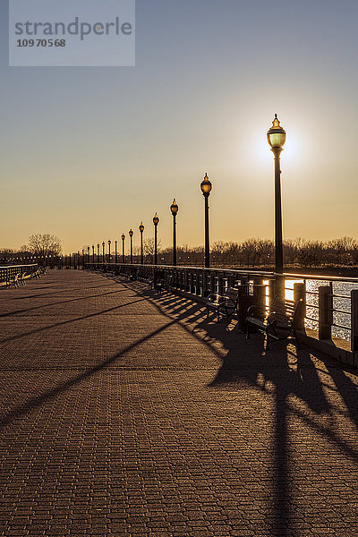 Sonnenuntergang hinter Laternenpfählen  Liberty State Park; Jersey City  New Jersey  Vereinigte Staaten von Amerika'.