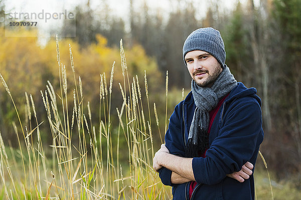 Porträt eines gut aussehenden jungen Erwachsenen  der einen Herbstausflug im Park genießt; Edmonton  Alberta  Kanada'.