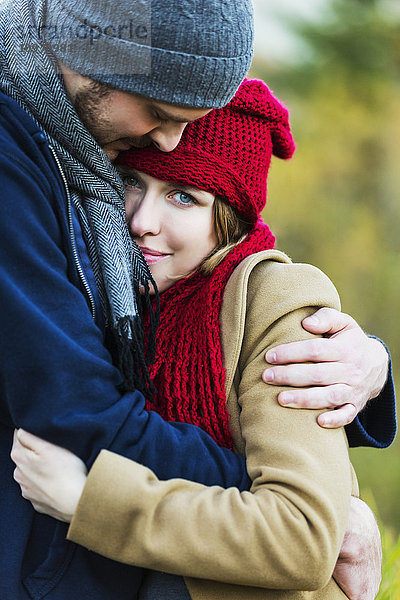 Ein junges Paar  das sich im Herbst in einem Stadtpark umarmt; Edmonton  Alberta  Kanada'.