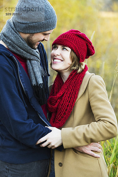 Ein junges Paar  das sich in einem Stadtpark im Herbst eng umarmt und in die Augen schaut; Edmonton  Alberta  Kanada