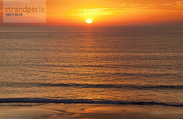 Eine goldene Sonne  die am Horizont über dem Meer versinkt; Andalusien  Spanien'.