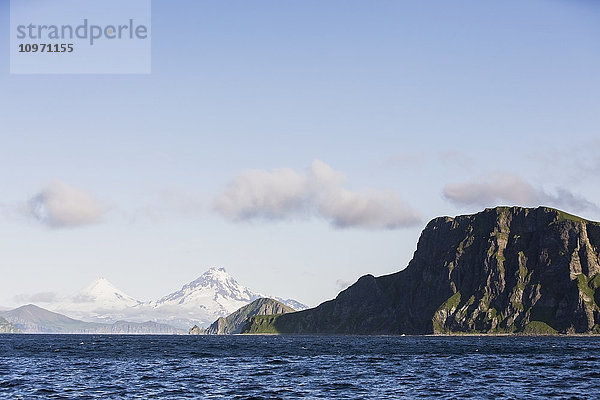 Shishaldin-Vulkan und Isanotski-Gipfel im Hintergrund der zerklüfteten Felsküste von Cape Pankof auf der Insel Unimak  östliche Aleuten; Südwest-Alaska  Vereinigte Staaten von Amerika'.