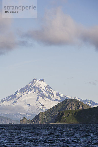 Shishaldin-Vulkan und Isanotski-Gipfel im Hintergrund der zerklüfteten Felsküste von Cape Pankof auf der Insel Unimak  östliche Aleuten; Südwest-Alaska  Vereinigte Staaten von Amerika'.