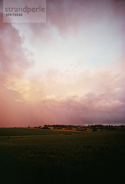 Sonnenuntergang mit Wolken über einem Alfalfa-Feld im Mittleren Westen der Vereinigten Staaten; Vereinigte Staaten von Amerika
