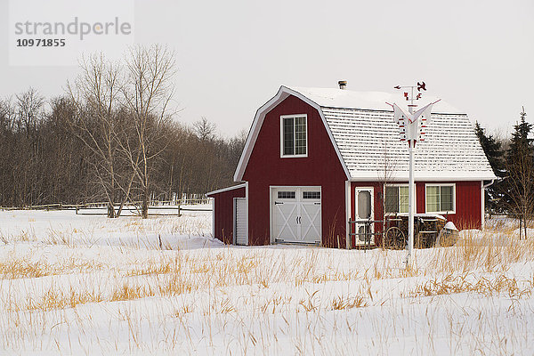 Ein rotes Scheunenhaus auf dem Lande im Winter; Winnipeg  Manitoba  Kanada