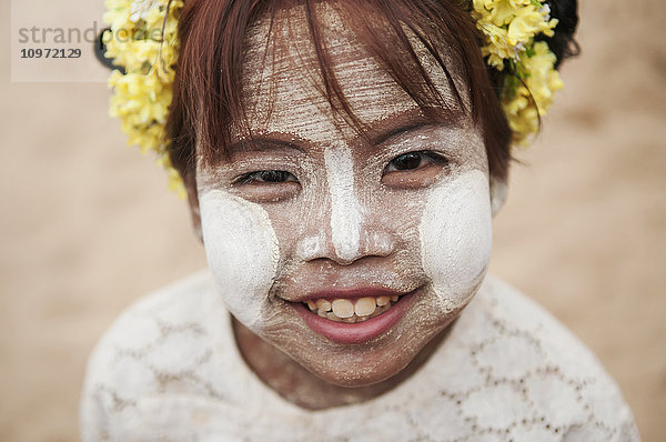 Junges Mädchen mit weißer Gesichtsbemalung und Blumen im Haar; Bagan  Myanmar'.