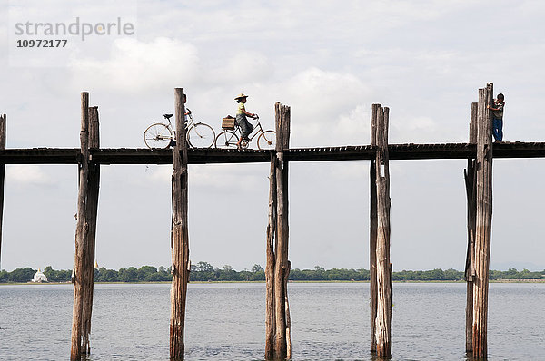 Fahrräder auf einer erhöhten Holzbrücke über den Taungthaman-See; Amarapura  Myanmar'.