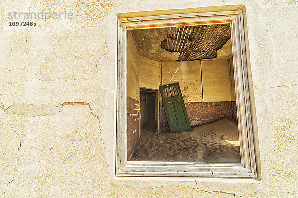Sand in den Räumen eines bunten und verlassenen Hauses; Kolmanskop  Namibia