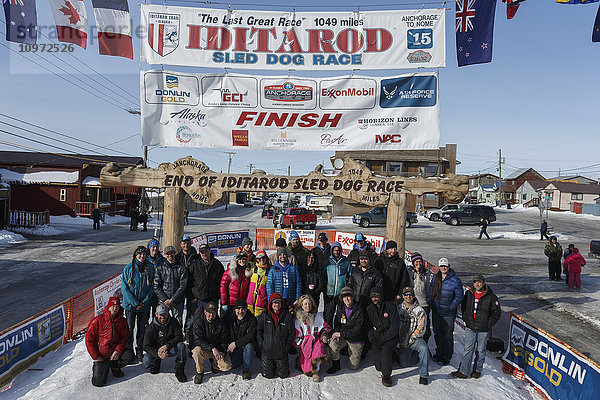Ein Teil der Musher  die das Iditarod 2015 am Samstag  den 21. März um 14 Uhr beendet haben  stellen sich an der Ziellinie in Nome für ein Gruppenfoto auf