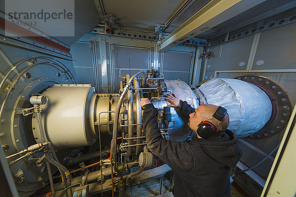 Arbeiter an einem elektrischen Kraftwerk  Gasturbinengenerator und Antriebswelle  Prudhoe Bay  Arktisches Alaska  USA  Sommer