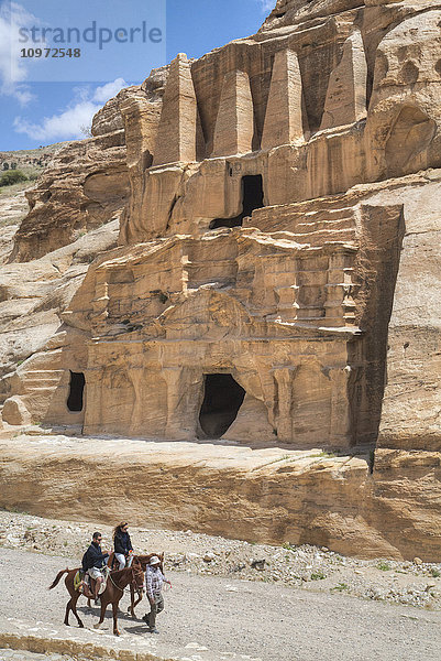 Touristen auf Pferden  Obeliskengrab (obere Struktur)  Bab as-Sig Triclinium (untere Struktur); Petra  Jordanien'.