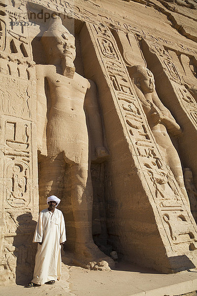Einheimischer am Tempeleingang  Statue von Ramses II. (links)  Statue der Königin Nefetari (rechts)  Hathor-Tempel der Königin Nefertari  Tempel von Abu Simbel; Nubien  Ägypten'.