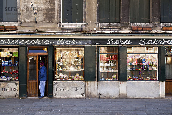 Ein Mann steht in der Tür eines Einzelhandelsgeschäfts; Venedig  Italien'.