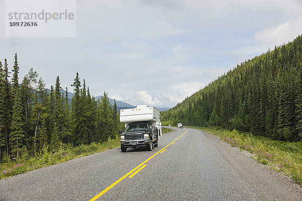 Lastwagen und Wohnmobil fahren auf dem Alaska Highway  westlich von Fort Nelson  British Columbia  Kanada  Sommer