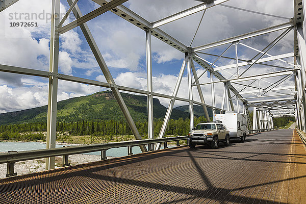 Auto und Anhänger überqueren eine Metallbrücke über den Racing River  Alaska Highway  westlich von Fort Nelson  British Columbia  Kanada  Sommer