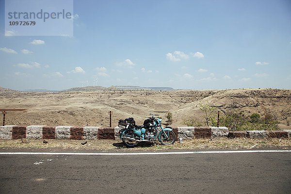 Mythisches Motorrad Royal Enfield mit Gepäck  geparkt am Straßenrand  Western Ghats; Karnataka  Indien'.