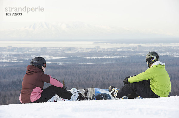 Ein Paar schnallt seine Snowboards auf dem Gipfel des Hilltop-Skigebiets in Anchorage  Alaska  an