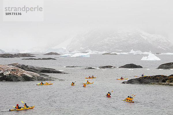 Touristen beim Seekajakfahren um Pleneau Island  Antarktische Halbinsel; Antarktis'.