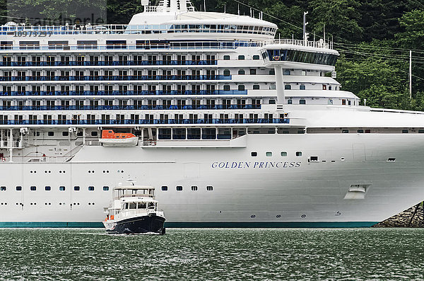 Kreuzfahrtschiff Golden Princess in Juneau  Alaska  mit einem Charter-Fischerboot im Vordergrund  Südost-Alaska