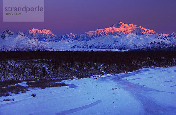 Winterliche Aussicht auf den Mt. McKinley und die Alaska-Kette bei Sonnenaufgang mit dem zugefrorenen Chulitna River im Vordergrund  Süd-Zentral-Alaska