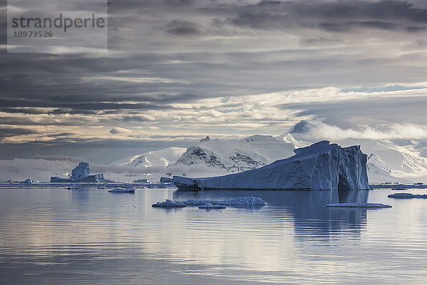 Eisberg in der Gerlache-Straße vor vergletscherten Gipfeln auf der Antarktischen Halbinsel; Antarktis'.