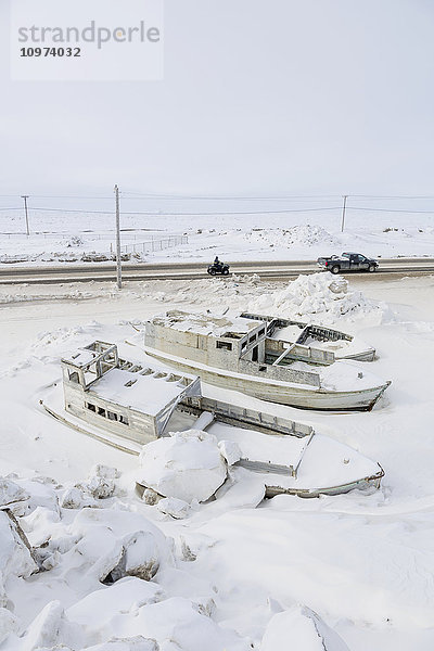 Kleine Boote eingefroren in Schneebänken neben einer Straße  Meereis im Hintergrund  Barrow  North Slope  Arctic Alaska  USA  Winter