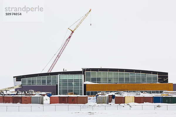 Schneebedeckte Schiffscontainer und ein Kran umgeben den Bau eines neuen Krankenhauses  Barrow  North Slope  Arctic Alaska  USA  Winter'.