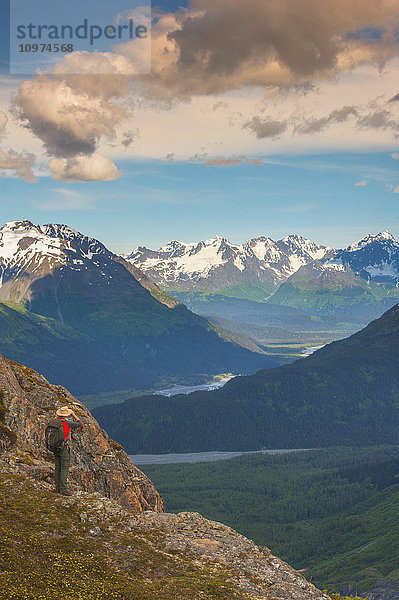 Ein Mann wandert in der Nähe des Harding Icefield Trail mit den Chugach Mountains und dem Resurrection Valley im Hintergrund  Kenai Fjords National Park  Süd-Zentral-Alaska